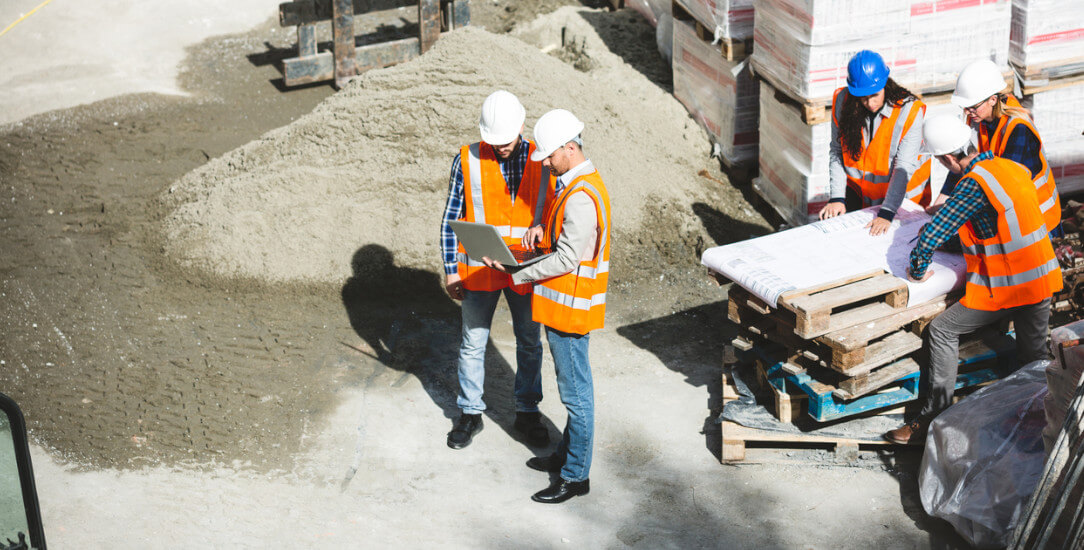 Construction team surveying the work of concrete robotics and site printing robots at a worksite