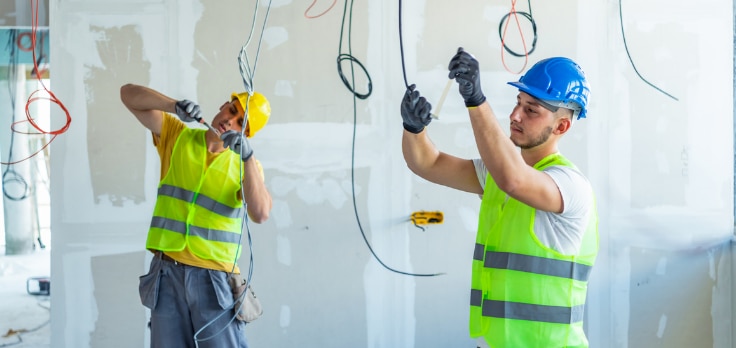 Electricians quickly installing wiring following layout markings from electrical engineering robotics for construction