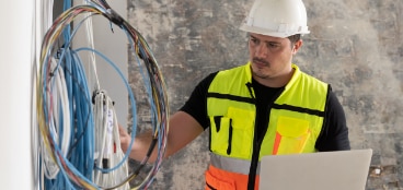 Electrical engineer inspecting wiring as part of a strategy to ensure electrical safety in building construction
